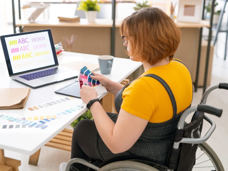 Pretty designer in casualwear choosing color for website design from palette Pretty designer in casualwear choosing color for website design from palette